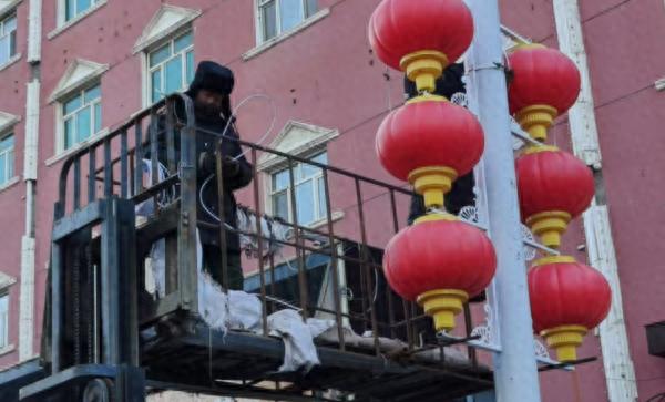 寒风中工人的双手被冻得通红，却为新年增添了一抹亮丽的中国红